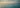 Ocean safety scene — calm tropical sea with a subtle rip-current pattern and a distant swimmer.
