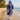 Asian woman in SAILBEE hooded beach robe walking on tropical sand.