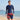 Model wearing the LYNDDORA navy long-sleeve rash guard and striped boardshorts on a sunny beach