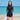 Model wearing the black half-zip rash guard swim set on a sunny beach